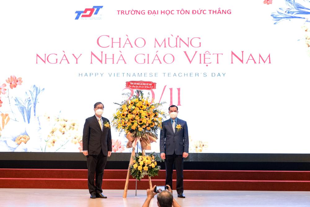 Đồng chí Nguyễn Đình Khang tặng hoa cho đại diện Nhà trường.