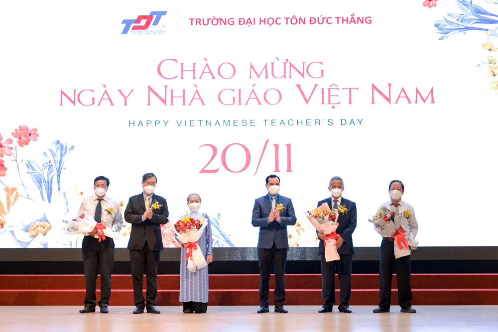 Đồng chí Nguyễn Đình Khang và PGS. TS. Vương Đức Hoàng Quân tặng hoa tri ân các thầy cô là thành viên Hội đồng sáng lập Trường Đại học Tôn Đức Thắng.